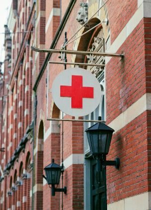 Red cross sign on a clinic building | Urgent Care in Tosmur | Online Doctor & Online Prescription | E-rx.online